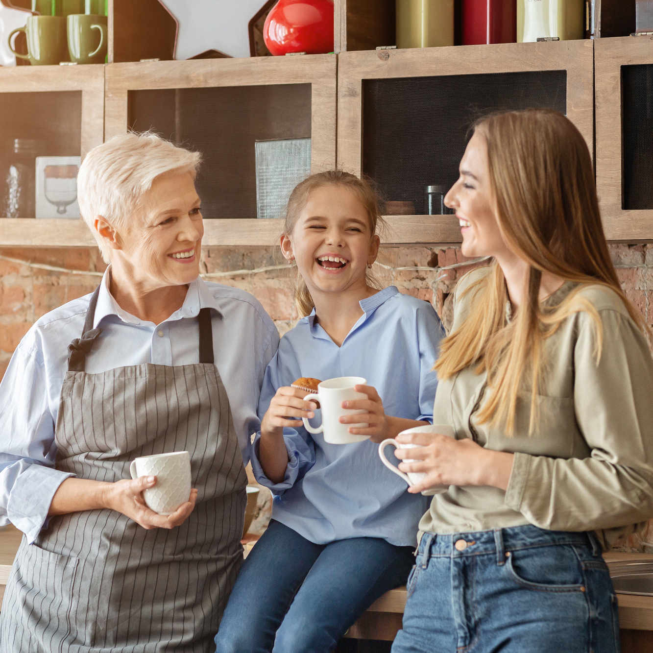 Female family drinking tea and laughing at kitchen