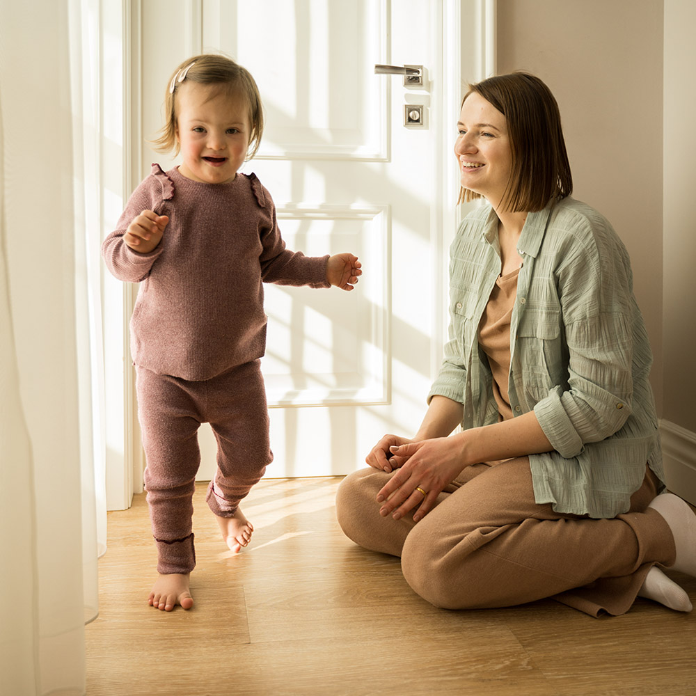 Full length view of the mother playing with her daughter with down syndrome at their apartments